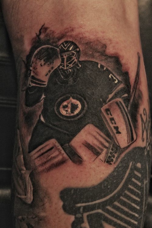 Chad Fabian gets a Winnipeg Jets tattoo applied to one of his calves Wednesday night by artist Dave Nazgul at 13th Hour Tattoo.  150415 April 15, 2015 Mike Deal / Winnipeg Free Press