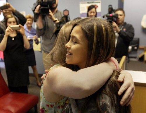 Samantha Rae Lussier , 25, hugs Allexis Siebrecht, 11, right, who needs a liver transplant in the offices of the Canadian Liver Foundation Manitoba Chapter  ( CLFM)- Lussier met Shiebrect  today in downtown Winnipeg after she went through the experience of going through the testing as a potential living liver donor- which in the end failed . Lussier and the CLFM announced that  they still raising funds for Allexis with the online campaign as well as selling support bracelets. - See Alex Paul story- Apr 16, 2015   (JOE BRYKSA / WINNIPEG FREE PRESS)