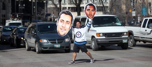 Local hockey nut Ron Cantiveros poses walking around downtown with this giant Ondrej Pavelec and Dustin Byfuglien head/photos. It looks goofy, in a good way. See Rany Turner's story. April 16, 2015 - (Phil Hossack / Winnipeg Free Press)