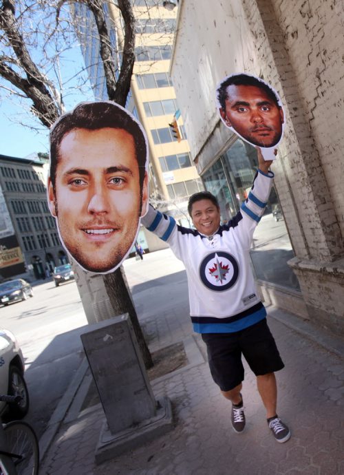 Local hockey nut Ron Cantiveros poses walking around downtown with this giant Ondrej Pavelec and Dustin Byfuglien head/photos. It looks goofy, in a good way. See Rany Turner's story. April 16, 2015 - (Phil Hossack / Winnipeg Free Press)