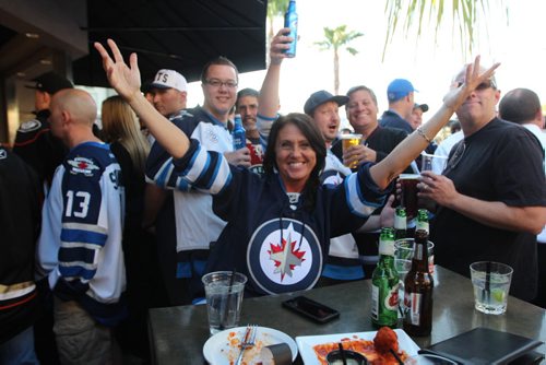 Jan Miller, a former Winnipegger who now lives in Anahiem, throws two arms up in favour of her hometown team ahead of Game 1 between the Winnipeg Jets and Anaheim Ducks Thursday night. (Jeff Hamilton / Winnipeg Free Press)