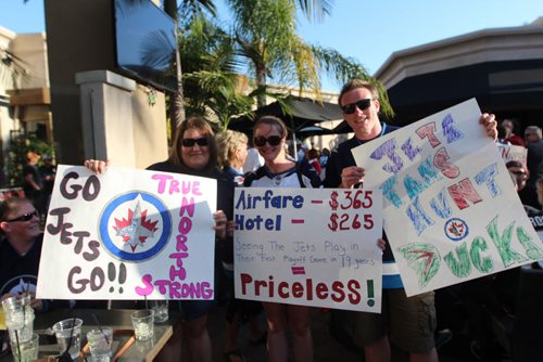 (From L-R) Christine Slobodian, Lacey Friesen, and David Deroche show off their clever signs ahead of Game 1.