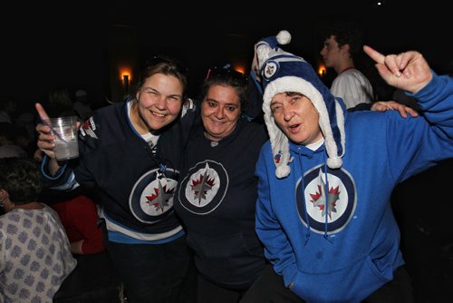 Debbie Dutka (left), Tracy Schaldemose (centre) and Heather Foster (right) cheer during a break in play at the Park Theatre where the Winnipeg Jets playoff game against the Anaheim Ducks is being shown.    150416 April 16, 2015 Mike Deal / Winnipeg Free Press