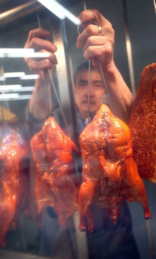Kim La holds up some BBQ'd Duck a'la Anaheim Friday afternoon in Sun Way,  his China Town Grocery store. See story / Illustration. April 17, 2015 - (Phil Hossack / Winnipeg Free Press)