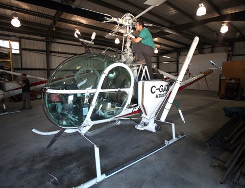 Aureo Agulha, a pilot with Winnipeg's Insect Control Program inspects one of the choppers he flys to deliver insecticide to the problem. See release/story. April 17, 2015 - (Phil Hossack / Winnipeg Free Press)