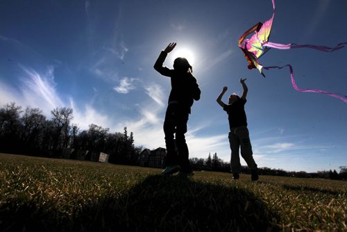 Ten-year-old Charmony (name is Charmony) Guimond (front) tries to get her kite in the air with the help of her friend Crosby Wright (rear) at Assiiboine Park Saturday afternoon.   Standup photo  Ruth Bonneville / Winnipeg Free Press April 18, 2015