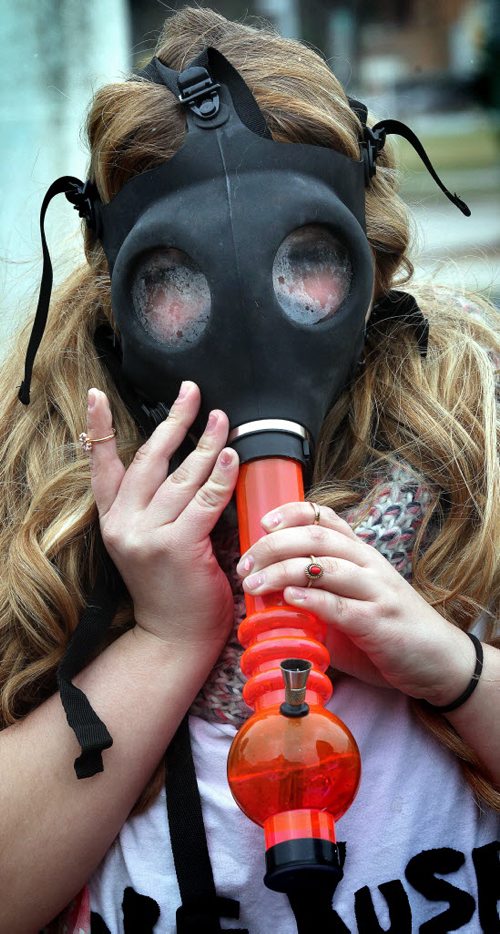 Gas Mask Gasp, a 4:20 participant uses a bong fastened to a gas mask to smoke up on the legislature's lawn Monday afternoon as about 700 participants gathered to rally for the legalization of pot. See release. April 20, 2015 - (Phil Hossack / Winnipeg Free Press)