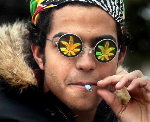 4:20 participant "Seif" enjoys a toke on the legislature's lawn Monday afternoon as about 700 participants gathered to rally for the legalization of pot. See release. April 20, 2015 - (Phil Hossack / Winnipeg Free Press)