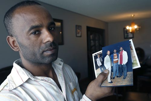 Hank Hongoro holds family photographs in his home in Winnipeg,  showing from right Hank with brothers Mathewos, Fikre and Markos.  The photos were taken in South Africa seven years ago.  Hank Hongoro whos sponsored Ethiopian refugees like himself and is now trying to sponsor his brothers who are stuck in South Africa where they and many other refugees are victims of xenophobic violence. Carol Sanders story Wayne Glowacki/Winnipeg Free Press April 21 2015