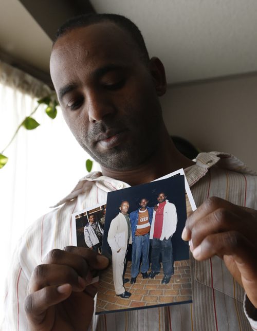 Hank Hongoro holds family photographs in his home in Winnipeg,  showing from right Hank with brothers Mathewos, Fikre and Markos.  The photos were taken in South Africa seven years ago.  Hank Hongoro whos sponsored Ethiopian refugees like himself and is now trying to sponsor his brothers who are stuck in South Africa where they and many other refugees are victims of xenophobic violence. Carol Sanders story Wayne Glowacki/Winnipeg Free Press April 21 2015