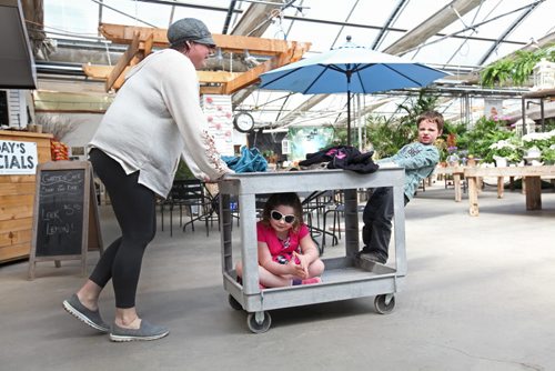 49.8 Feature page on Gardening.  Photos taken at Shelmerdine Garden Centre.  Six-year-old Mya Rhyse enjoys a ride at the bottom of a cart while her brother Richard, 4 years rides and runs in front while mom Tracy enjoys an afternoon browsing through the greenhouse recently.   Ruth Bonneville / Winnipeg Free Press April 21, 2015