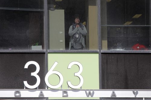 Haz Mat scene at 363 Broadway. A person on the second floor watches as the suspicious package gets dealt with. BORIS MINKEVICH/WINNIPEG FREE PRESS APRIL 23, 2015
