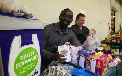 Patrick Fosu-Siaw and Tammy Watson with Winnipeg Harvest ,happily fill gently used plastic bags that have been donated to Wpg. Harvest for starter kits of food.  Using recycled bags eliminates buying thousands of new bags that could end up in the landfill.    Ruth Bonneville / Winnipeg Free Press April 23, 2015