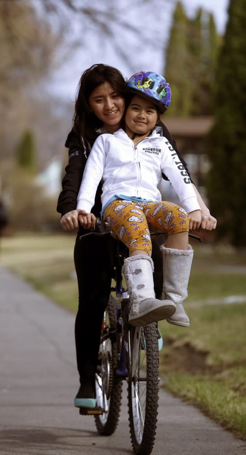 Charisse Salud gives her younger sister Ariam Leira  a ride through their Boyd Ave. neighbourhood  Friday afternoon. Wayne Glowacki / Winnipeg Free Press April 24 2015
