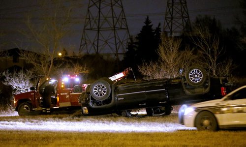 Police at the scene where a truck rolled over in the grass along Bishop Grandin near Lakewood Blvd, late Friday, April 24, 2015. (TREVOR HAGAN/WINNIPEG FREE PRESS)