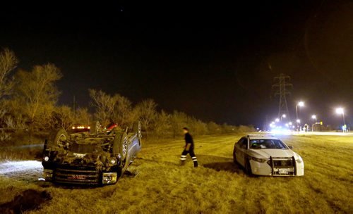A tow truck and Police at the scene where a truck rolled over in the grass along Bishop Grandin near Lakewood Blvd, late Friday, April 24, 2015. (TREVOR HAGAN/WINNIPEG FREE PRESS)