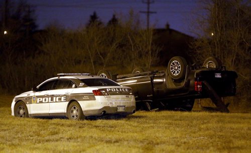 Police at the scene where a truck rolled over in the grass along Bishop Grandin near Lakewood Blvd, late Friday, April 24, 2015. (TREVOR HAGAN/WINNIPEG FREE PRESS)
