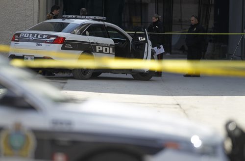 Police at the scene of a homicide behind a parking garage at the corner of Hargrave Street and Ellice Avenue, Saturday, April 25, 2015. (TREVOR HAGAN/WINNIPEG FREE PRESS)