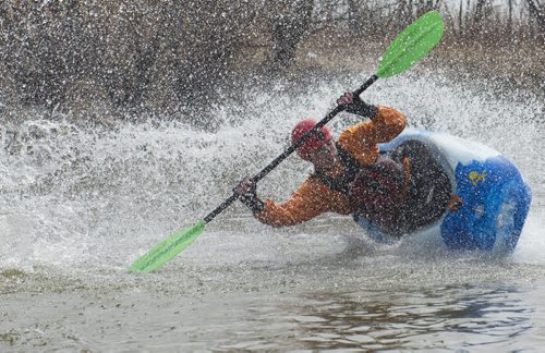 150426 DAVID LIPNOWSKI / WINNIPEG FREE PRESS  Alex Martin of the Manitoba Whitewater Club performs tricks in his kayak after sliding down the toboggan slide Sunday April 26, 2015 at FortWhyte Alive for the Earth Day Celebration.