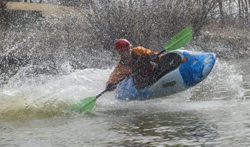 150426 DAVID LIPNOWSKI / WINNIPEG FREE PRESS  Alex Martin of the Manitoba Whitewater Club performs tricks in his kayak after sliding down the toboggan slide Sunday April 26, 2015 at FortWhyte Alive for the Earth Day Celebration.