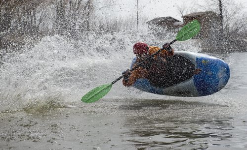 150426 DAVID LIPNOWSKI / WINNIPEG FREE PRESS  Alex Martin of the Manitoba Whitewater Club performs tricks in his kayak after sliding down the toboggan slide Sunday April 26, 2015 at FortWhyte Alive for the Earth Day Celebration.