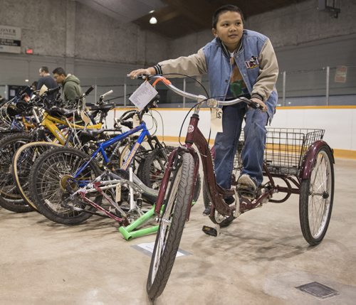 150426 DAVID LIPNOWSKI / WINNIPEG FREE PRESS  Renzo Macaraig (9) tests out a Schwinn tricycle Sunday April 26, 2015 at the annual City of Winnipeg Bike Auction at Century Arena.