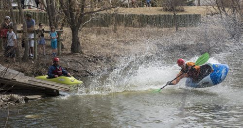 150426 DAVID LIPNOWSKI / WINNIPEG FREE PRESS  Alex Martin of the Manitoba Whitewater Club performs tricks in his kayak after sliding down the toboggan slide Sunday April 26, 2015 at FortWhyte Alive for the Earth Day Celebration.