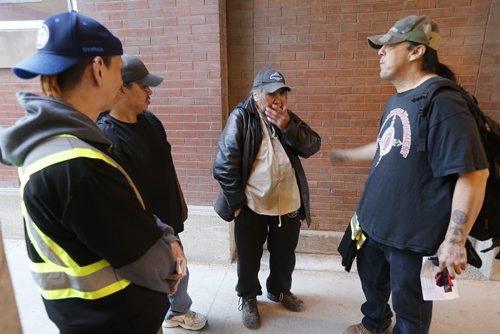 April 26, 2015 - 150426  -   Vin Clarke, Morley Hill and Harrison Friesen show Jimmy Miles (C) a police supplied photo of a person of interest in the homicide of two homeless people and encourage him to go to a shelter and get off the street Sunday, April 26, 2015. John Woods / Winnipeg Free Press