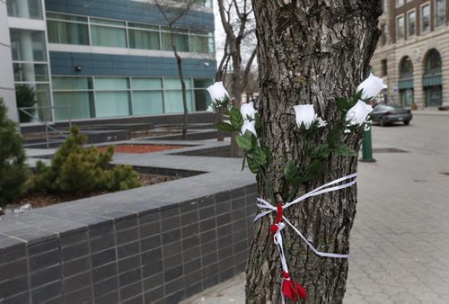 Flowers at the scene along the sidewalk on Carlton St. near Portage Ave. Monday morning from a vigil held Sunday for the two men killed on the weekend.Wayne Glowacki / Winnipeg Free Press April 27 2015