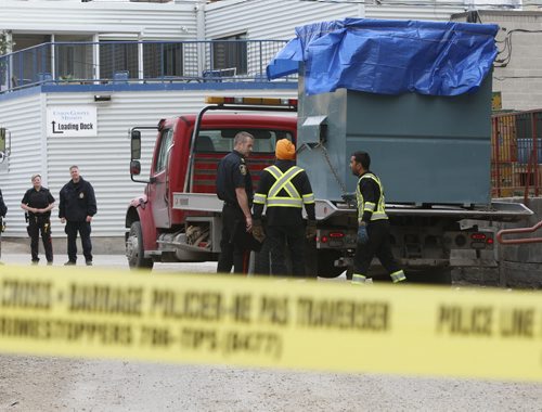 Winnipeg Police at the loading docks behind the Siloam Mission Monday morning as the garbage bins are being loaded. Wayne Glowacki / Winnipeg Free Press April 27 2015