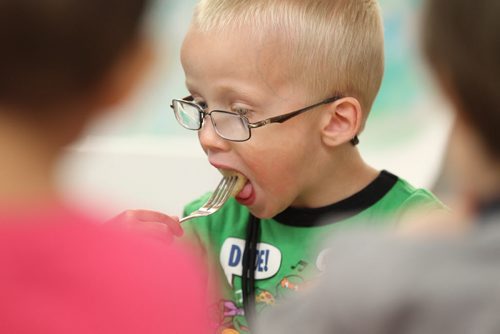 49.8   Feature photos on Early Childhood Educators working with kids at Splash Child Enrichment Centre on McGregor Street.  Pre-school boy enjoying his lunch with his playmates.  See Mary Agnes Welch story.   Ruth Bonneville / Winnipeg Free Press April 28, 2015