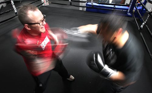 Glove whir around Roland Vandal as he spars with Jerome Busch, a former champion youth boxer returning to the ring after and absence from Elite Gym where Vandal trains his boxers. See Geoff Kirbyson story re:boxer turned author. April 28, 2015 - (Phil Hossack / Winnipeg Free Press)