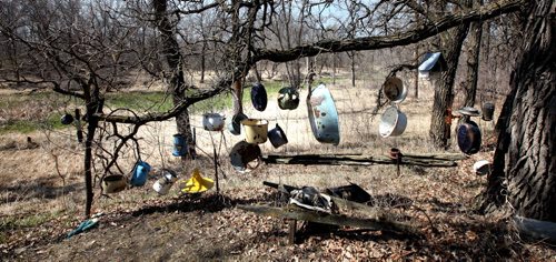 Enameled pots and pans scrounged from old mining camps in Manitobas north hang as a "wind chime at Real Berard's St Pierre retreat. He's an artist, canoe route mapper, and political cartoonist. See Bill Redekop's story. April 29, 2015 - (Phil Hossack / Winnipeg Free Press)