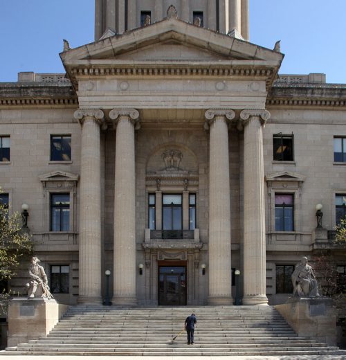 An employee at the Manitoba Legislative Building sweeps the accumulated winter dirt from the steps of the west entrance Thursday afternoon. 150430 - Thursday, April 30, 2015 -  (MIKE DEAL / WINNIPEG FREE PRESS)