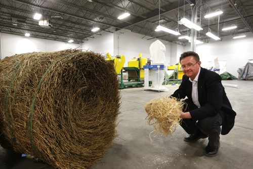 Simon Potter,  v.p. Product Inovation at FibreCITY, The Composites Innovation Centre beside a round flax bale, holding  flax fibre made from decortication equipment in back in the pilot scale area .   Martin Cash Wayne Glowacki / Winnipeg Free Press April 30 2015