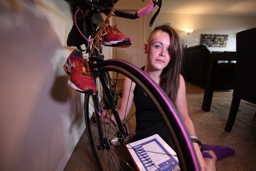 Joanne Schiewe sits close to her new pink running shoes and pink rimmed race bike that she recently splurged on for some upcoming triathlon events that she is excited about racing in even though she recently had brain surgery to remove a tumour.  This Sunday she will be running in the WPS half marathon which she has raised over $13,000 dollars in less than one month to go toward fighting brain cancer.   See Adam Wazny's story.   Ruth Bonneville / Winnipeg Free Press April 29, 2015
