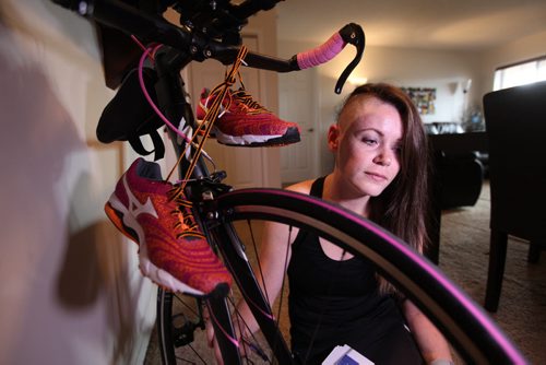 Joanne Schiewe sits close to her new pink running shoes and pink rimmed race bike that she recently splurged on for some upcoming triathlon events that she is excited about racing in even though she recently had brain surgery to remove a tumour.  This Sunday she will be running in the WPS half marathon which she has raised over $13,000 dollars in less than one month to go toward fighting brain cancer.   See Adam Wazny's story.   Ruth Bonneville / Winnipeg Free Press April 29, 2015