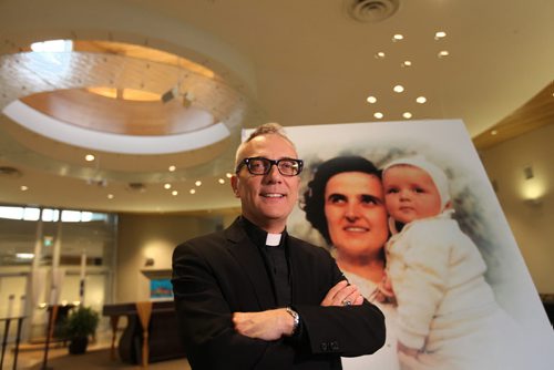 Faith Page. Rev. Darren Gurr in St. Gianna's Roman Catholic Church which will have the  First Canadian shrine to St. Gianna  Betetta Molla in the new RC church in Winnipeg.  Portrait of St. Gianna with child in photograph.  April 30, 2015 Ruth Bonneville / Winnipeg Free Press