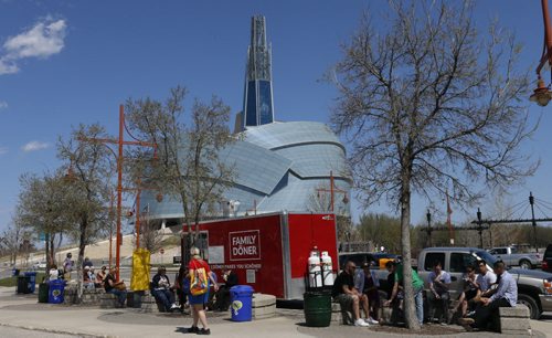 A crowd eats at the Family Döner, one of three food trucks on Israel Asper Way between the Canadian Museum for Human Rights and The Forks Market on Monday, the first day of the summer pilot project. Ten food trucks were selected to take part and will take turns as only a maximum of four trucks allowed at one time. Wayne Glowacki / Winnipeg Free Press May 1 2015