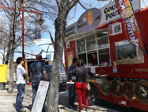 The Poutine King was taking orders, it is  one of three food trucks on Israel Asper Way between the Canadian Museum for Human Rights and The Forks Market on Monday, the first day of the summer pilot project. Ten food trucks were selected to take part and will take turns as only a maximum of four trucks allowed at one time. Wayne Glowacki / Winnipeg Free Press May 1 2015