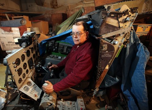 Chris Bell, an electronics and aircraft junkie sits in a simulated cockpit of a jet fighter in one of the hangars at Bob Diemert's  "Friendship Field" airstrip at Carman Mb. See Bill Redekop story.  May 1, 2015 - (Phil Hossack / Winnipeg Free Press)