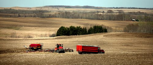 Farm equipment roams the rolling countryside near Cardinal Mb Friday morning. A dry spring has opened fields to an earlier seeding this year. STAND UP. May 1, 2015 - (Phil Hossack / Winnipeg Free Press)