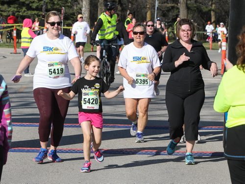 Jamie Morrison (left) and her daughter Marley, 6, cross the finish line with other participants in the Winnipeg Police Half-Marathon at Assiniboine Park Sunday morning. 150503 - Sunday, May 03, 2015 -  (MIKE DEAL / WINNIPEG FREE PRESS)