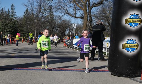 Declan Fisher, 5 (left) and his sister, Ayla, 8 (right) cross the finish line together during the Winnipeg Police Half-Marathon at Assiniboine Park Sunday morning. 150503 - Sunday, May 03, 2015 -  (MIKE DEAL / WINNIPEG FREE PRESS)
