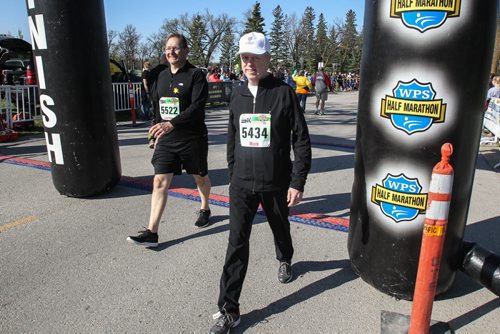 Lawrence Traa (left) who has brain cancer and Mark McDonald, the executive director of the Canadian Cancer Society's Manitoba Division cross the finish line together during the Winnipeg Police Half-Marathon at Assiniboine Park Sunday morning. 150503 - Sunday, May 03, 2015 -  (MIKE DEAL / WINNIPEG FREE PRESS)