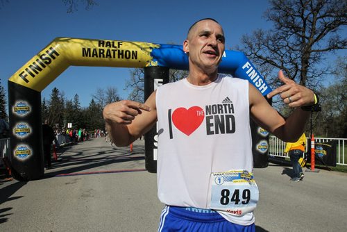 Kevin Chief points to his shirt after finishing the Winnipeg Police Half-Marathon at Assiniboine Park Sunday morning. 150503 - Sunday, May 03, 2015 -  (MIKE DEAL / WINNIPEG FREE PRESS)
