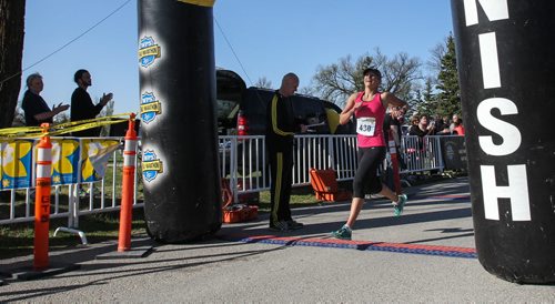 Nicole Walker is the first female to cross the finish line during the Winnipeg Police Half-Marathon at Assiniboine Park Sunday morning. 150503 - Sunday, May 03, 2015 -  (MIKE DEAL / WINNIPEG FREE PRESS)