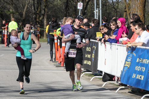 Courtney St. Croix (left) and husband Drew Dear carry their one- and three-year-old children toward the finish line during the Winnipeg Police Half-Marathon at Assiniboine Park Sunday morning. 150503 - Sunday, May 03, 2015 -  (MIKE DEAL / WINNIPEG FREE PRESS)