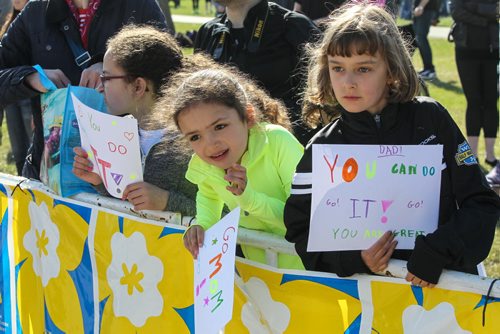 Yasmeen Shalaby, 10 (left), Natalie Shalaby, 7 (centre) and Monica Renaue, 8 (right) hold signs for their parents during the Winnipeg Police Half-Marathon at Assiniboine Park Sunday morning. 150503 - Sunday, May 03, 2015 -  (MIKE DEAL / WINNIPEG FREE PRESS)