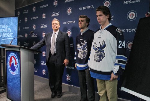 Winnipeg Jets GM Kevin Cheveldayoff introduces Manitoba Moose players Scott Kosmachuk (right) and JC Lipon (left) who are modelling the new jersey for the Winnipeg Jets affiliate AHL team which is moving back to Winnipeg next season.  150504 May 4, 2015 Mike Deal / Winnipeg Free Press